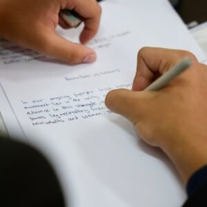A person writing on a piece of paper